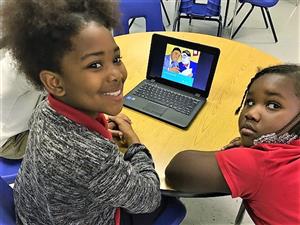 Two students watching an educational video on a computer